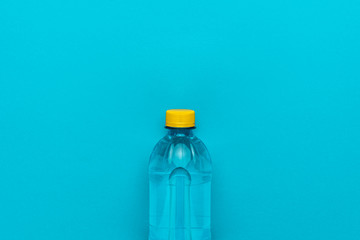 plastic water bottle with yellow cap on the blue background
