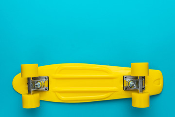 minimalist flat lay photo of cruiser skateboard over turquoise blue background
