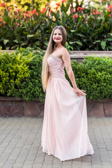 Urban portrait of young, slim, beautiful model in pink dress