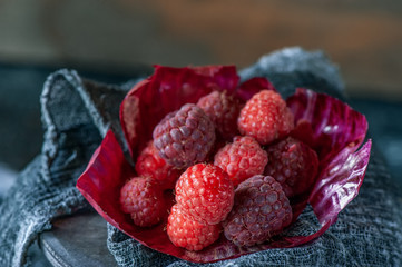 Ripe juicy raspberries on the table close-up. Rustic