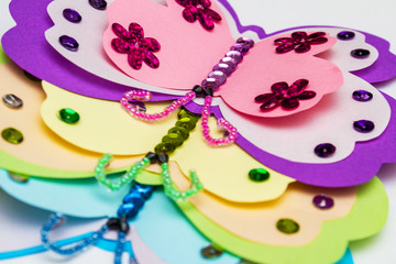 Application made with hot melt glue gun. Three butterflies made of colored paper, multi-colored...