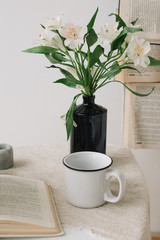 Spring still life. Breakfast in bed. White bedroom. Sweet home. Books, flowers and coffee cup. flat lay