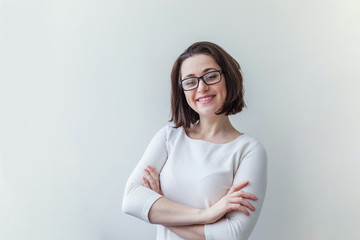 Beautiful happy girl smiling. Beauty simple portrait young smiling brunette woman in eyeglasses isolated on white background. Positive human emotion facial expression body language. Copy space