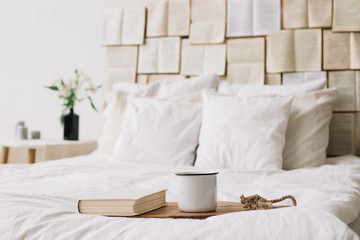 Spring still life. Breakfast in bed. White bedroom. Sweet home. Books, flowers and coffee cup. flat lay 