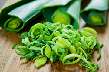 Fresh green leek vegetables on the wooden board.