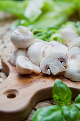 White button mushrooms on the wooden board.