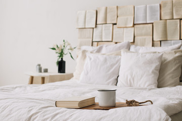 Spring still life. Breakfast in bed. White bedroom. Sweet home. Books, flowers and coffee cup. flat lay 