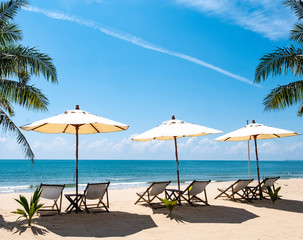 Beautiful scenery of chairs and white umbrellas on the beach, the sea of relaxation in the summer. Copy space banner