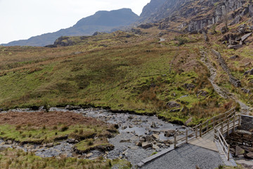 Wooden bridge on the Cwmorthin Waterfall trail in the mountains of Snowdonia National Park, Wales.