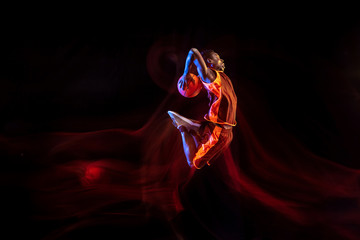 Fight for being the first. African-american young basketball player of red team in action and neon...