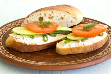 Vegetarian sandwiches with cream cheese, cucumbers and tomatoes, healthy snack.
