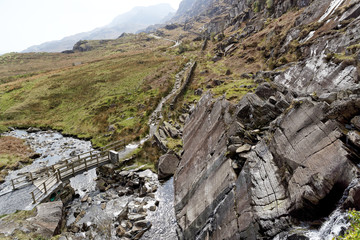 Wooden bridge on the Cwmorthin Waterfall trail in the mountains of Snowdonia National Park, Wales.