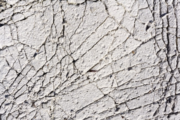 Cracked concrete texture background. Grey surface with cracks close up. A lot of pieces of splintered plaster. Abstract concept of split, dissent, disagreement, discord. Sunny day with .