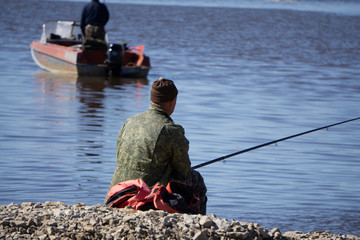 Cropped shot of a man tying a bait to his fishing rod. Close up of hands of a person fixing a bait...