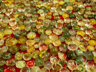 Beautiful natural glass stone. Bright pile of crystal stone. Luxurious variegated mineral Rutile Quartz on white fabric.Rutile in quartz gemstone