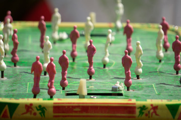 Detail of girl's hands playing the foosball vintage table match. Color toned image. Concept photo of leading the company