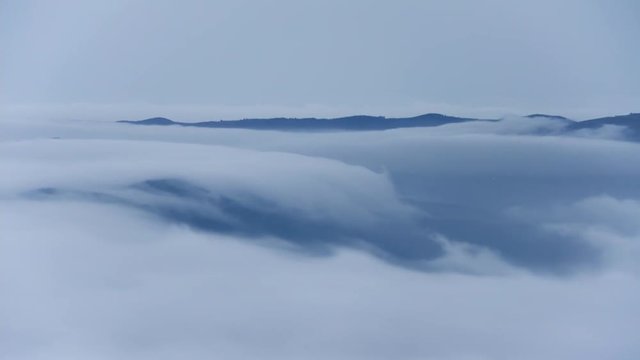 Cascade of clouds. Sea of clouds in mountainous landscape, Oiz mount basque country, Spain.