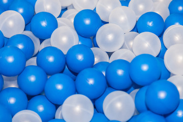 Close up of plastic white and blue balls in dry pool on the playground