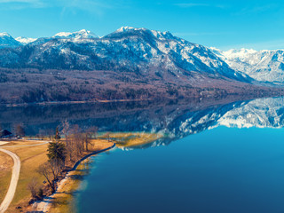 Obraz premium Mountain lake in early spring with snowy peaks. Beautiful nature. Reflection on the lake