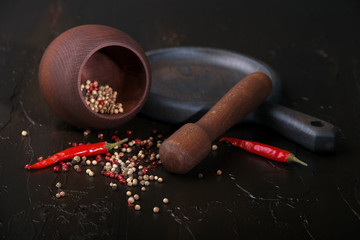 Wooden mortar for spices, spicy red peppers and pepper peas.