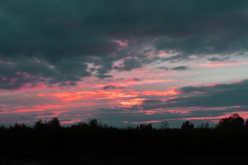 The setting sun silhouettes hills as it reflects upon the waters of the Ohio River as seen from Paden City, West .