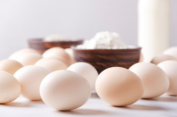 Closeup of eggs, four and glass of milk.Cooking process.Ingredients for preparing and mixing dough
