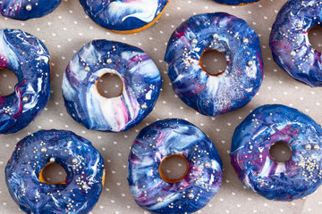 Set of donuts with cosmic icing and silver sprinkles.