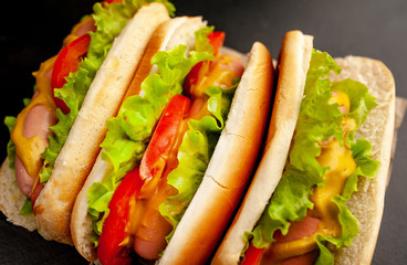 delicious hot dogs on a cutting board against a background of stone