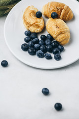 healthy light breakfast. blueberries, croissants on a plate with spikelets of wheat. Ingredients for yogurt. proper nutrition for a slim figure. raw food vegetarianism. diet