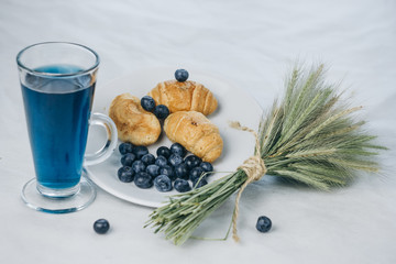 healthy light breakfast. Blue tea from orchids, blueberries, croissants on a plate with spikelets of wheat. Ingredients for yogurt. proper nutrition for a slim figure. raw food vegetarianism. diet