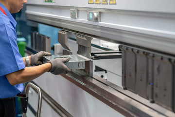 The technician operator use hydraulic bending machine. The sheet metal manufacturing process.