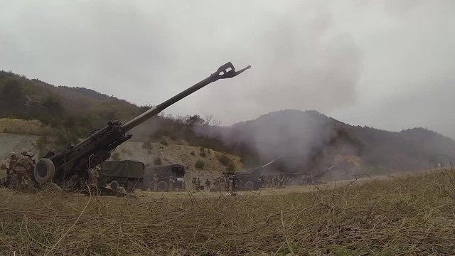 Soldiers Firing M777 Howitzers In An Open Field 3