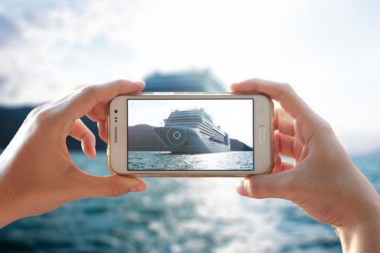 Photo camera of a smartphone. Young woman takes a photo of a cruiser.