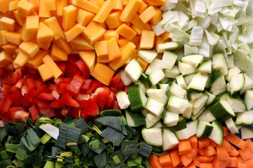 Various chopped vegetables: butternut squash, cabbage, red pepper, courgette, leek and carrot. Top view, selective focus.