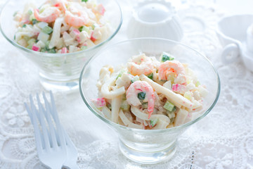 Salad with seafood: squid, shrimp, crab sticks in glass salad bowls, horizontal