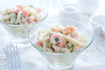 Salad with seafood: squid, shrimp, crab sticks in glass salad bowls, horizontal