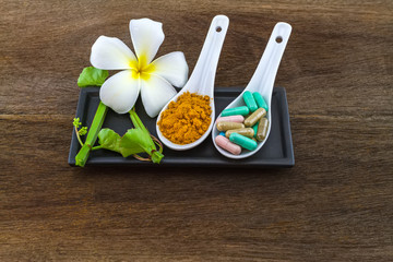 Spa herbal (white frangipani flowers, turmeric powder in white spoon ,pill,Cissus Quadrangularis Linn) on wooden background