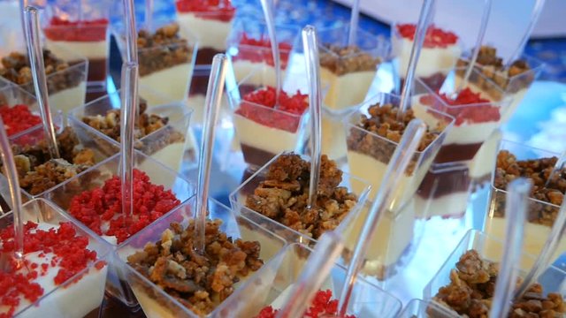 Tasty red and white jelly in glasses with spoons