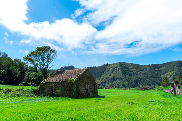 Fototapeta na wymiar Abandoned farm house building in the middle of green forest, Sao Miguel, Azores, Portugal.