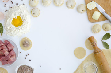Cooking traditional Russian pelmeni dumplings background frame. Ingredients, kitchen items for baking raviolis. Kitchen utensils, flour, eggs, meat,. Text space, top view