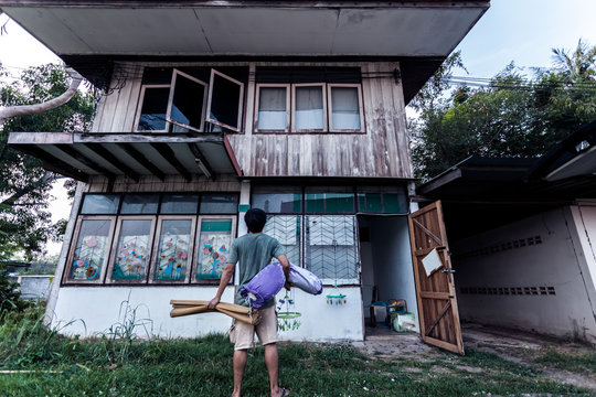 Poor man and mat with pillow stand on old wooden house with Thai style in black  tone