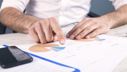 businessman with documents in the office; statistics chart