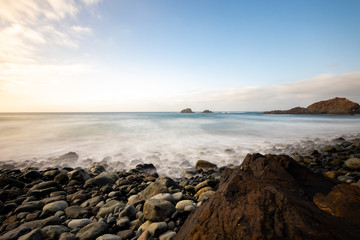 Obraz premium Sea view, marine panorama of the coast at sunset, sea, mountains, rocks, clouds and waves with soft light. Tenerife island coast and sea at sunset