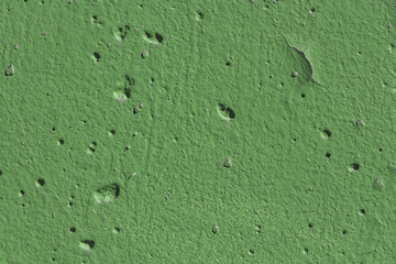 Beautiful horizontal texture of part of old concrete wall painted in green color with holes on the photo