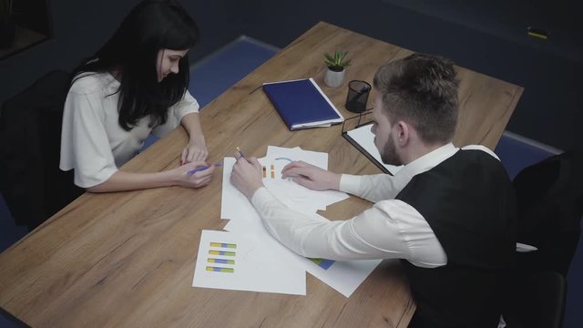Above view shot of graphic data templates table with business people analyzing growth rates and trends. Workplace. Office space.