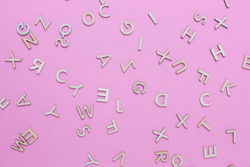 Wooden ABC alphabet letters on pink background
