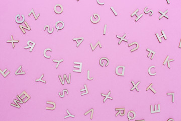 Wooden ABC alphabet letters on pink background