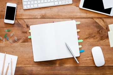 Open empty blank notebook organizer with pen for planning on work table with devices and...