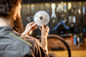 Repairman holding rear gear stars before installing them on a mountain bicycle at the workshop