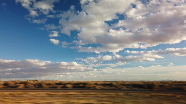 Side view driving plates beautiful desert landscape with cloudy blue sky 4k 24p